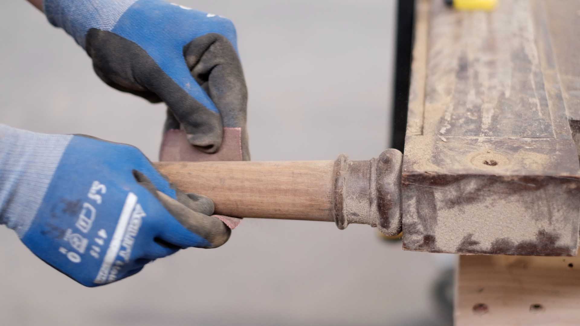 Carpintero retaurando la pata de una butaca de madera